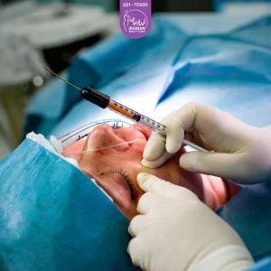 Doctor's hands holding a syringe containing fat graft and injecting fat into a woman's face - fat injection