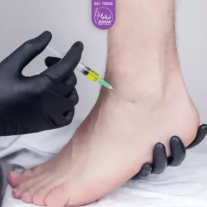 The feet of the person in the doctor's hand and with the other hand injecting fat into the person's ankle