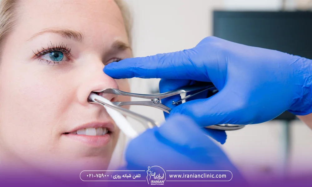 پزشک در حال انجام معاینه بعد از عمل انحراف بینی