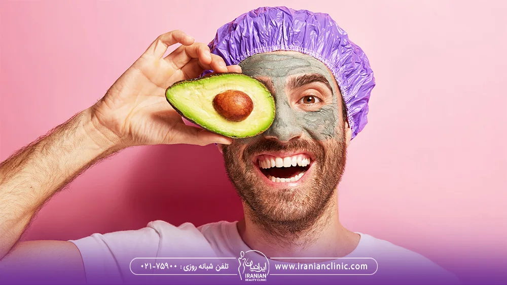 مردی که ماسک به صورت خود زده است و یک تکه آووکادو در دست دارد - ماسک صورت خانگی
