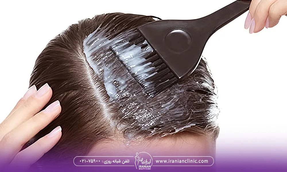 تصویر مربوط به یک خانم است که با فرچه ی رنگ در حال رنگ کردن موی سرش است.