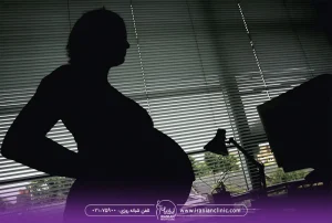 عکس زن حامله که جلوی پنجره ایستاده است