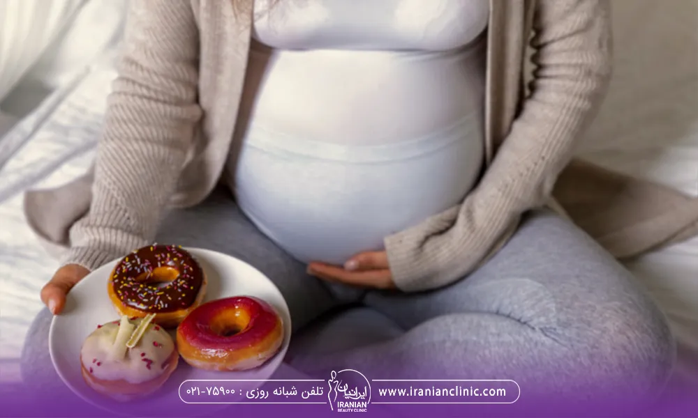 خانم بارداری که نشسته است و بشقاب غذا در دست دارد