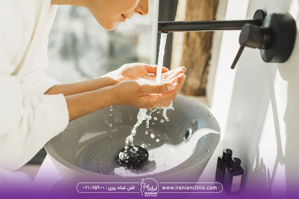 دختری که جلوی شیر آب ایستاده و صورت خود را می شوید