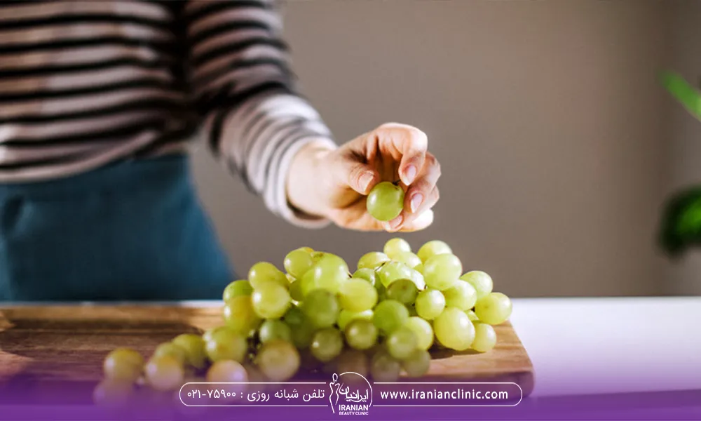 فردی که رژیم انگور دارد و یک حبه انگور ورداشته است تا بخوره