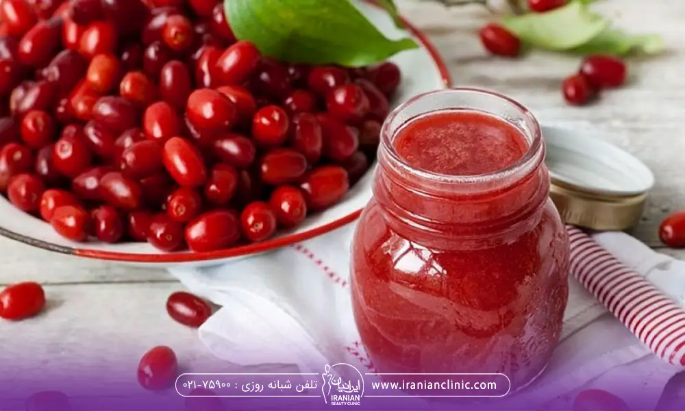 مقداری زغال اخته درون ظرف روی میز و شربت آن در یک شیشه در باز کنار ظرف رغال اخته و یک برگ روی میوه زغال اخته قرار دارد