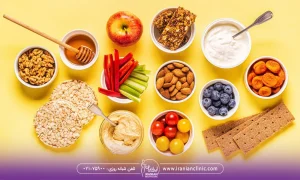 مواد غذایی شامل میوه ها و سبزیجات که روی یک سطح زرد رنگ قرار گرفته اند