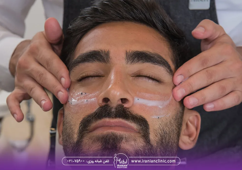 مردی که روی گونه های او کرم مالیده شده و ماساژ صورت دریافت می کند