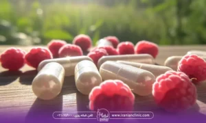چند تا تمشک قرمز که روی میز ریخته شده و در کنارش چندتا کپسول قرص که نشان دهنده قرص لاغری تمشک است