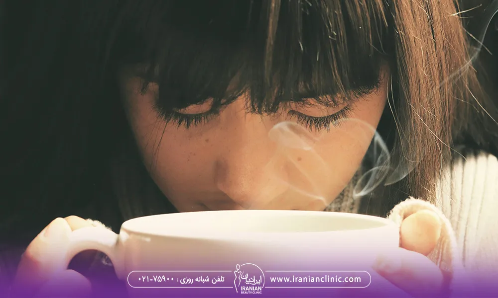 یک خانم در حال خوردن چای داغ