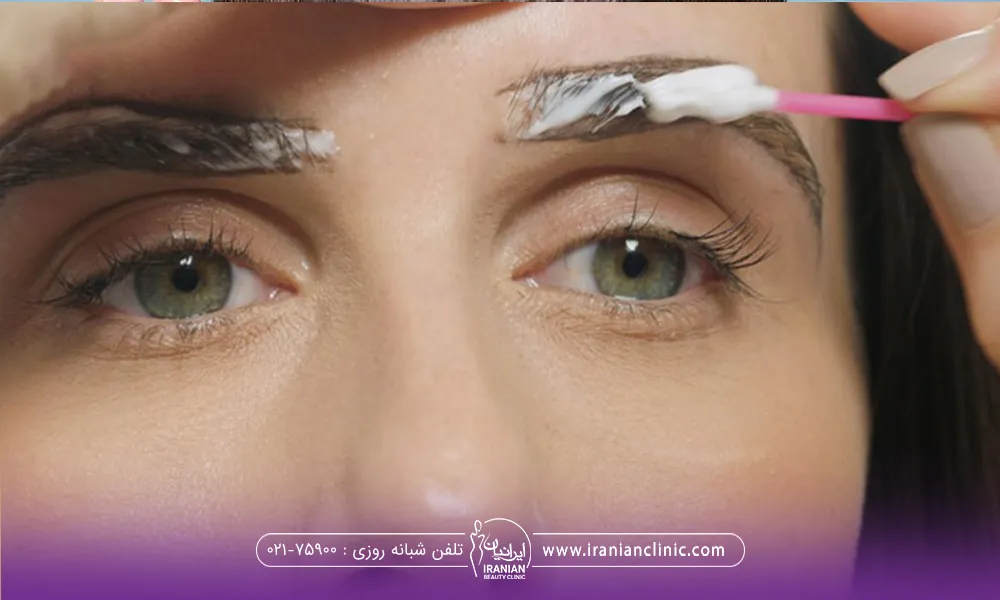 خانمی که خودش با یک گوش پاک کن در حال شستشوی ابروی خود میباشد 