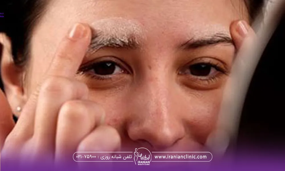 دختری که بعد از کاشت ابروی خود با دو انگشت خود جلوی آینه ابرو هایش را میشوید - نحوه شستشوی ابرو بعد از کاشت​
