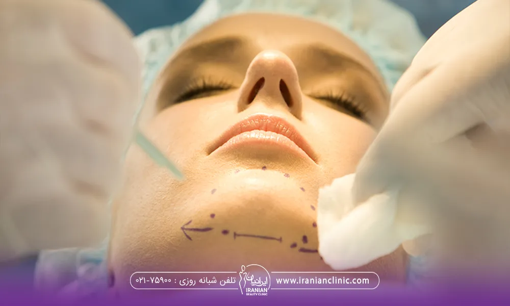 خانمی که خوابیده و دکتر در حال علامت گذاری روی چانه او برای تزریق چربی است