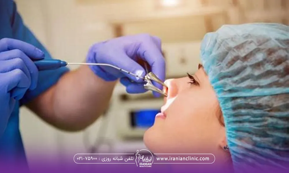 دختری که کلاه مخصوص جراحی به سر دارد و دستان دکتری که دستکش به دست دارد و در حال جراحی بینی میباشد