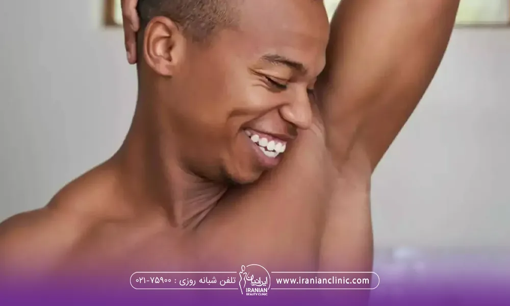 مرد خوشحالی که دست خود را بعد از لیزر موهای زائد زیر بغل بالا برده است و نگاه میکند