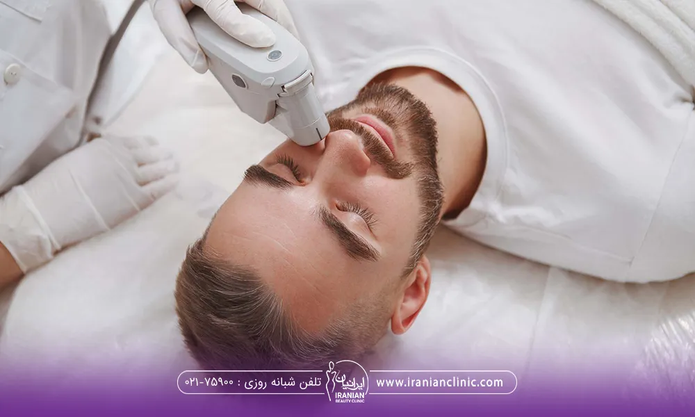 مردی که خوابیده است و دست اپراتور در حال لیزر کردن صورت فرد است