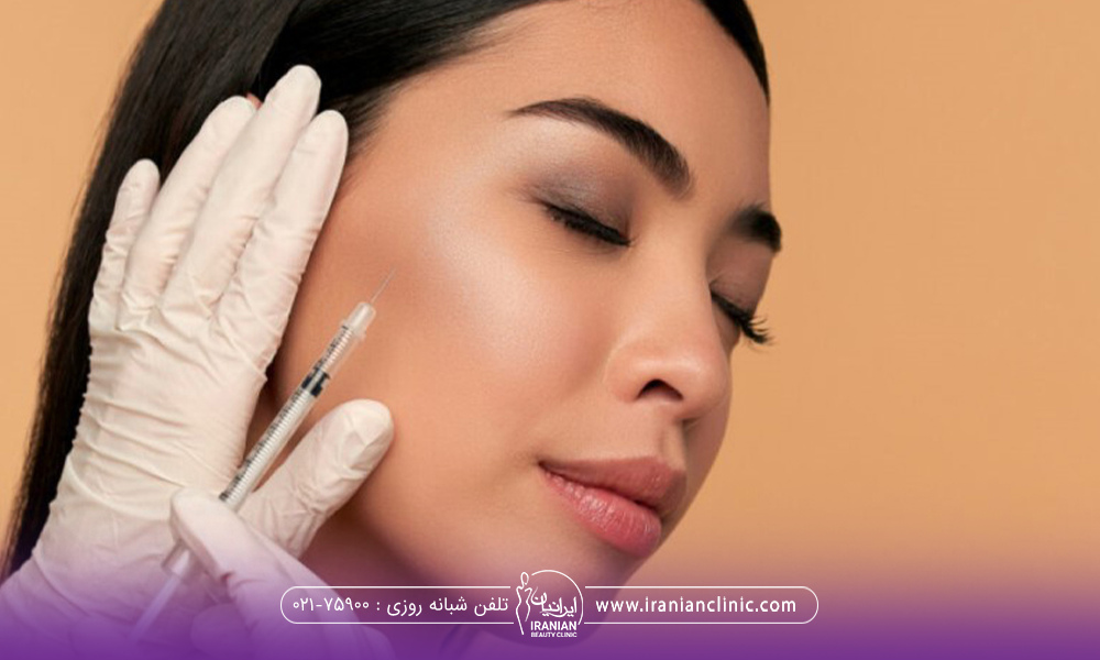 دختری سر خود را مایل به سمت چپ نگه داشته است و دست دکتر کنار صورت خانم است و با دست دیگر در حال تزریق ژل به گونه دختر است