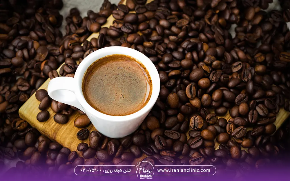 عکس یک فنجان قهوه که دور آن دانه های قهوه ریخته است