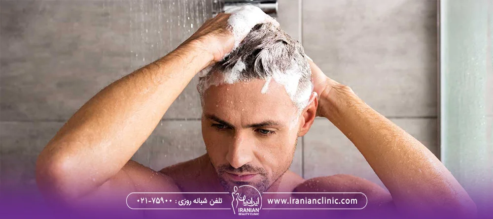 مردی که موهای خود را زیر دوش می شورد و به موهای خود شامپو زده است