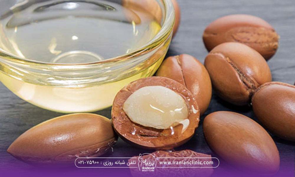 یک کاسه روغن آرگان در کنار دانه های آن