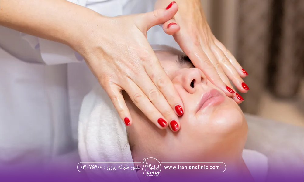 دستان فرد دیگری که لاک قرمز دارد در حال ماساژ دادن صورت دختر است
