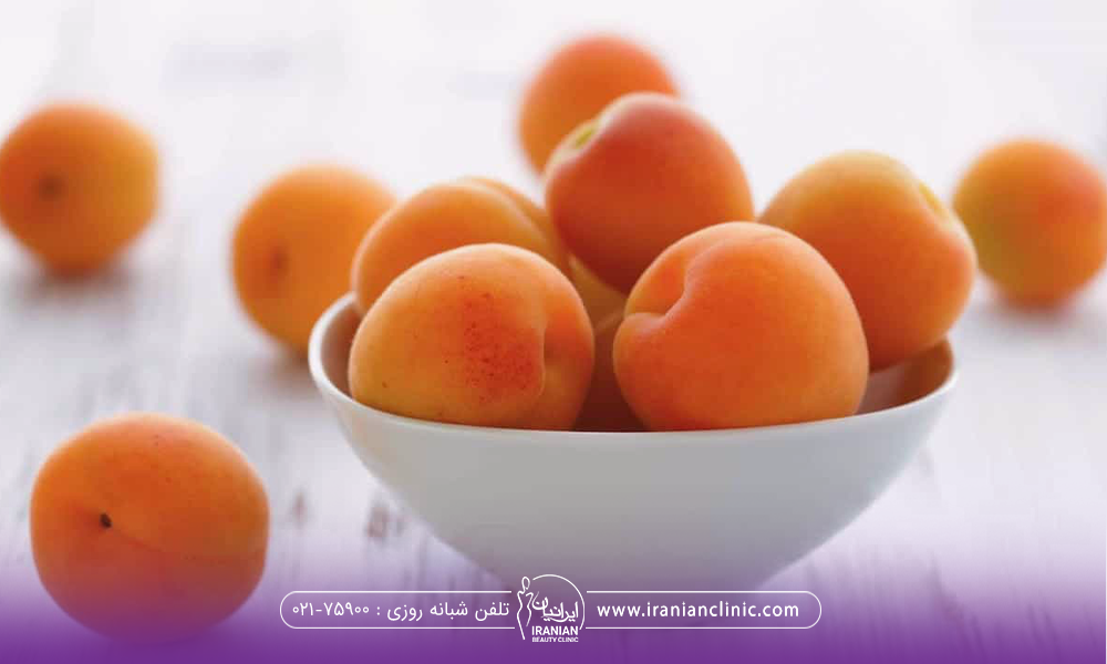 یک کاسه زردالو که چند تا زردالو هم بیرون از آن ریخته است