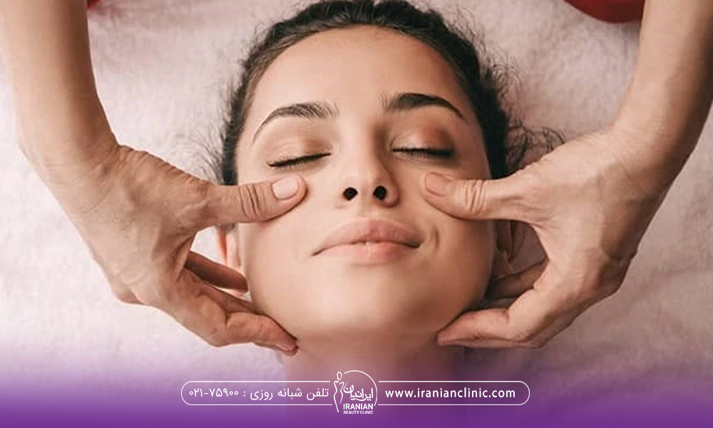 خانمی که خوابیده و دستان فرد دیگری که در حال ماساژ دادن صورت او است