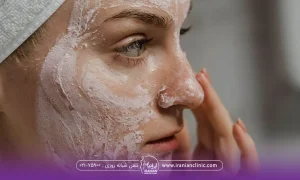 نیمرخ فردی که به آینه نگاه می کند و در حال زدن ماسک روی صورتش است - تاثیر جوش شیرین بر پوست