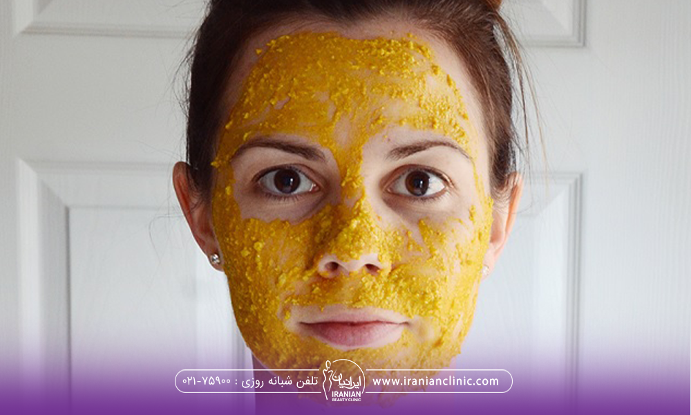خانمی که ماسک زردچوبه با سفیده تخم مرغ به صورتش زده و به رو به رو نگاه می کند