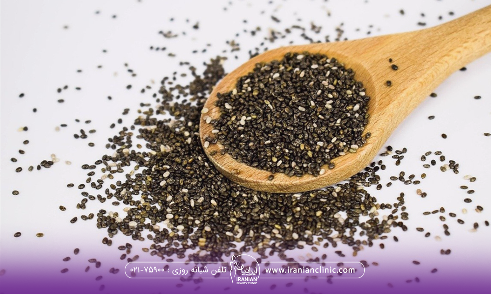 یک قاشق پر از تخم کرفس که مقداری از دانه ها از قاشق بیرون ریخته است